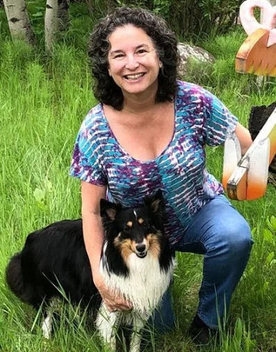 Beth Meyerson Sterkel sitting outdoors with her dog.